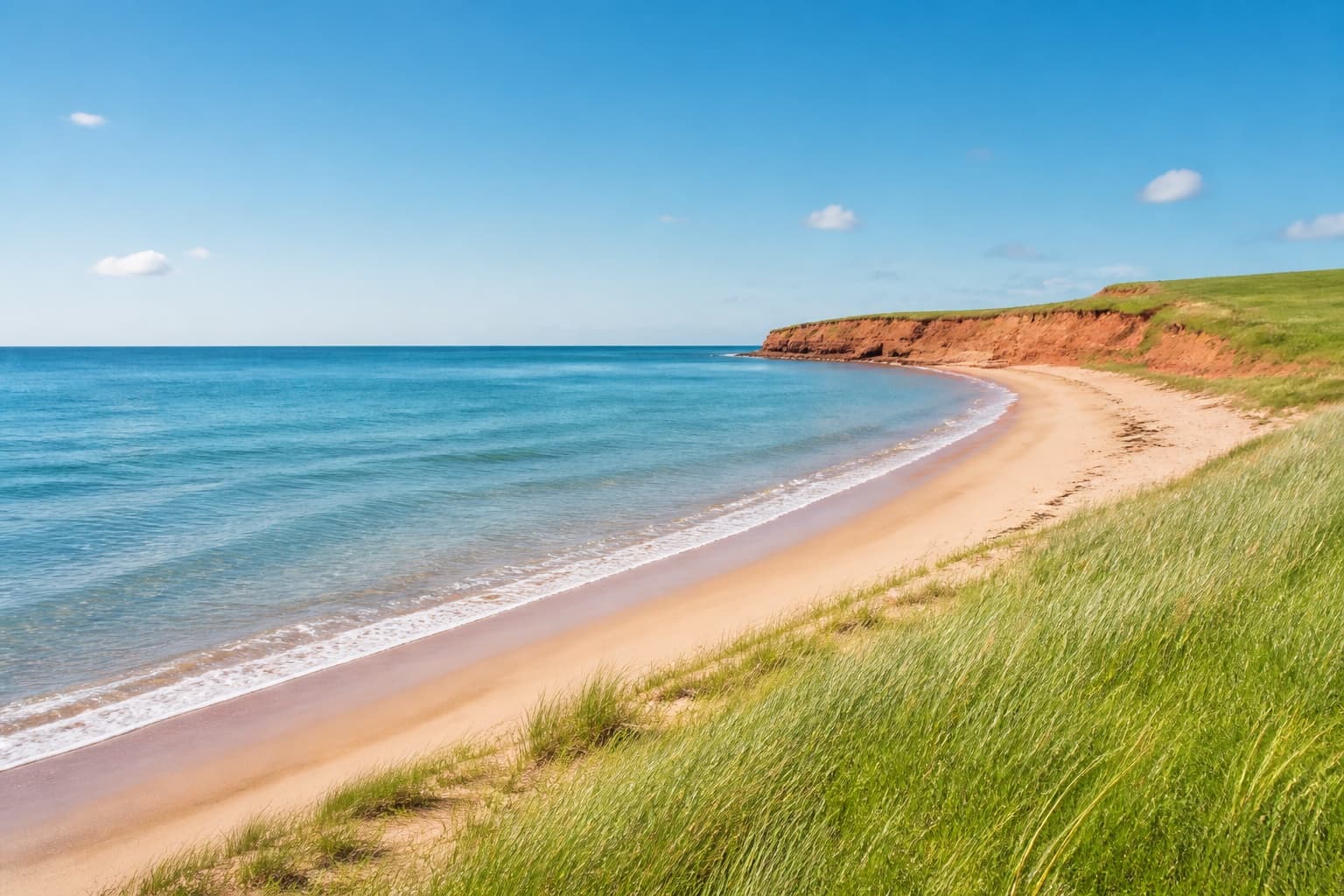 Sandy beach, grassy dunes and red cliffs on the eastern coast of Prince Edward Island